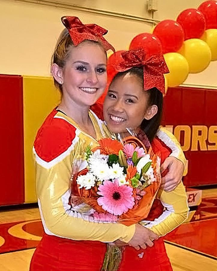 Senior Kayla Bunnell and sophomore Danielle Lee warmly embrace each other after the closing of the cheer showcase