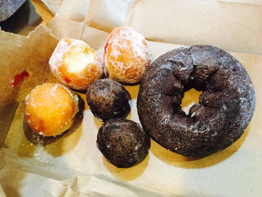 Dunkin Donuts provides an assortment of donuts and Munchkins, including chocolate glazed and strawberry jelly filled.  