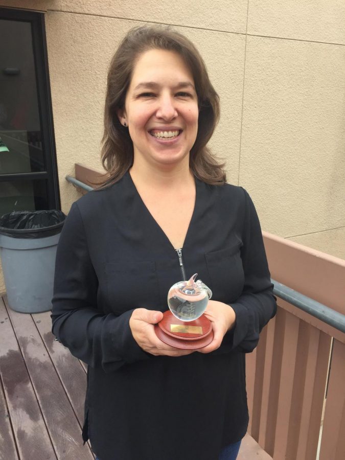 Drama teacher Cassandra Gaona holds her trophy, awarded to her after being named a Teacher of the Year.
