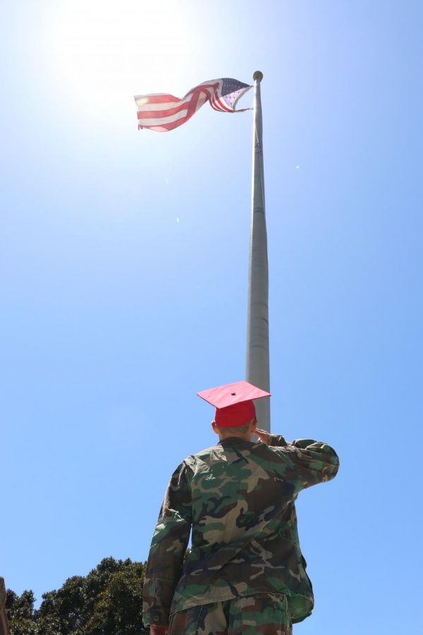 Junior Cody Billings salutes the American flag in full uniform.