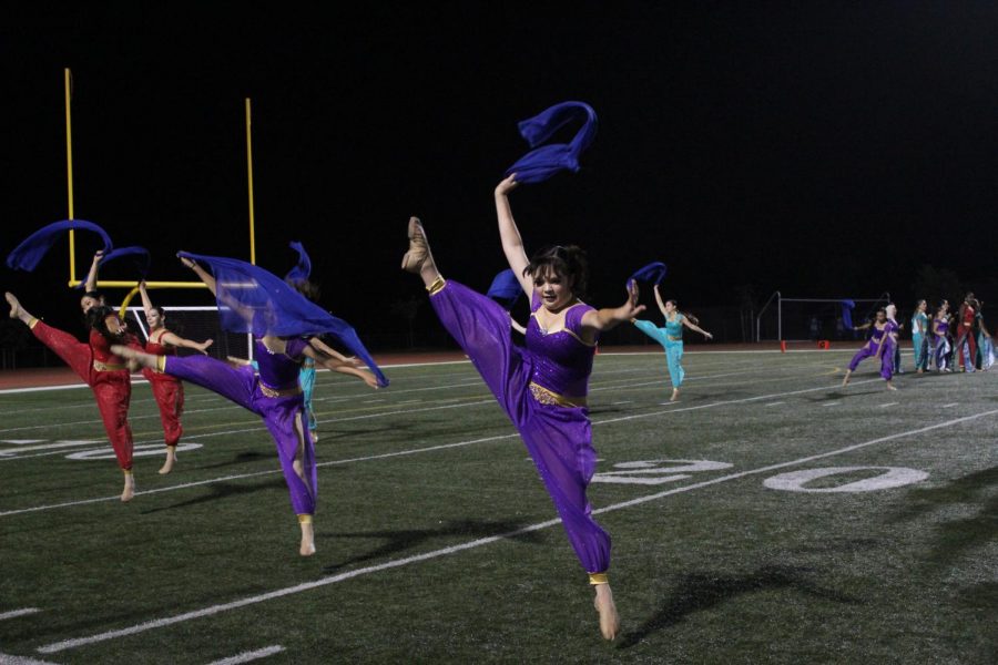 Dancers leap across the field to the marching band tunes.
