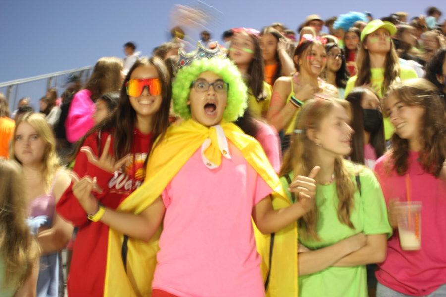 Yell Crew members pose while cheering at the neon home football game.