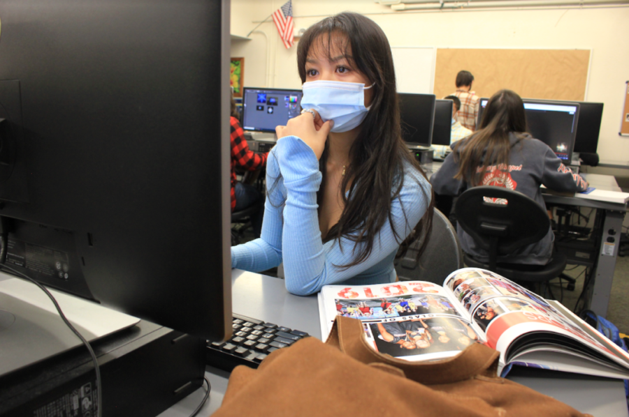 Junior and yearbook staff Natasha Le opens 2019 yearbook to gain inspiration.
