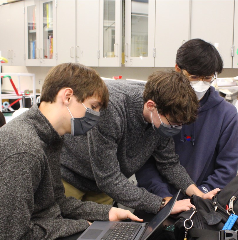 CubeSat members work collaboratively to complete one aspect of their satellite project.