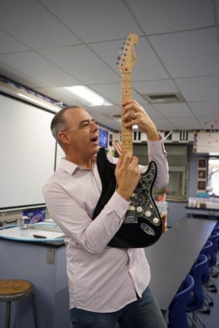 Physics teacher Robert Evans recreates the signature pose of legendary guitarist Eddie Van Halen, who was an inspiration to him growing up.