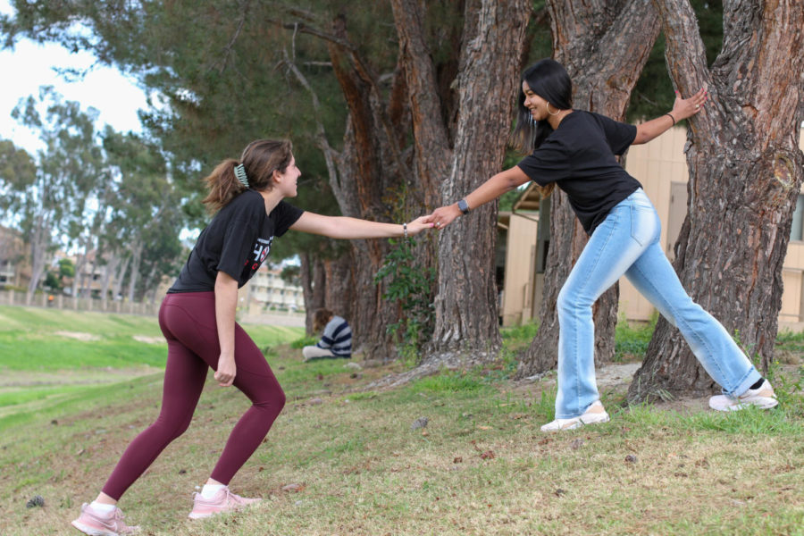 Sophomore Hope Squad members Haley Ferguson and Krisha Basu lend a helping hand toward one another.