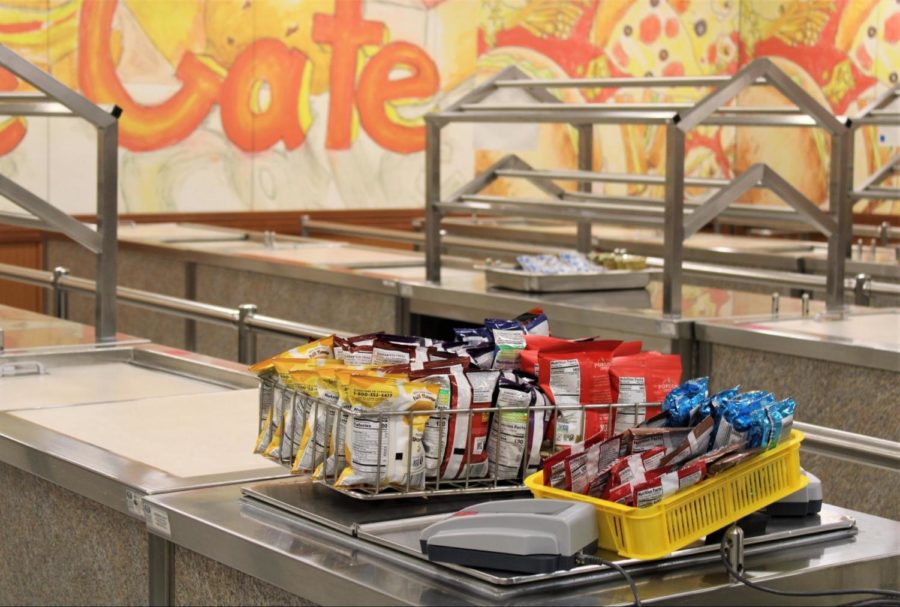 Two trays with various snacks, including chips, are placed on one of the cafeteria’s counters for students to pick up.