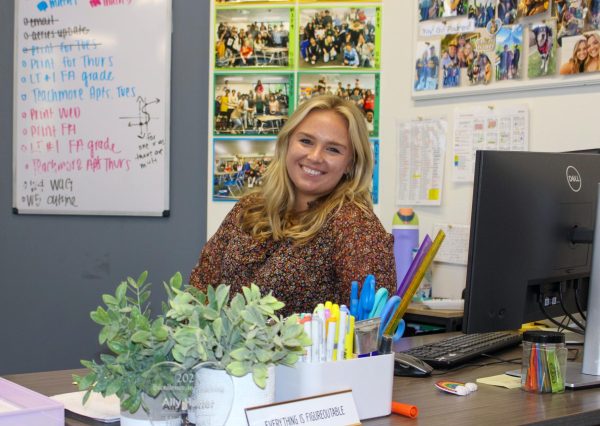 Math teacher Ally Hatter smiles at her desk, welcoming in her students for a new day of math.