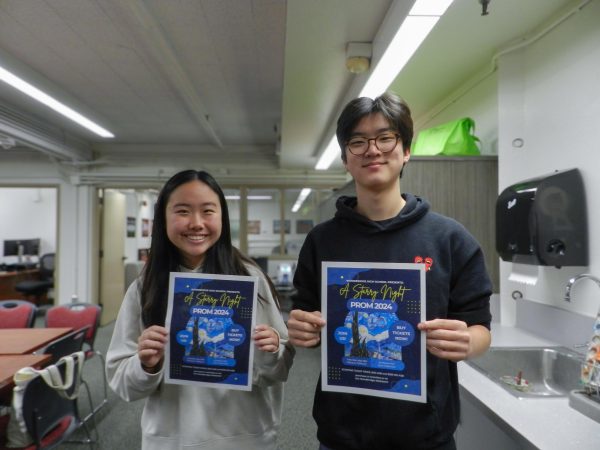 Juniors Matthew Chang and Jocelyn Gov hold up fliers for the upcoming Starry Night Prom.